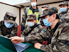 Mao Qing (right), an expert with a medical team from the Chinese army, works on protective measures in wards of Huoshenshan Hospital on February 5.