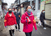 Weng Wenjing (front), Party secretary of Zhonghualu Street's Xichenghao Community in Wuhan, and two volunteers take to the street to promote coronavirus prevention and control measures on February 7.