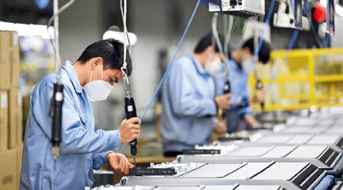 Masked workers on the assembly line of Guangzhou Skyworth Flat Display Technology Co., Ltd., February 10.