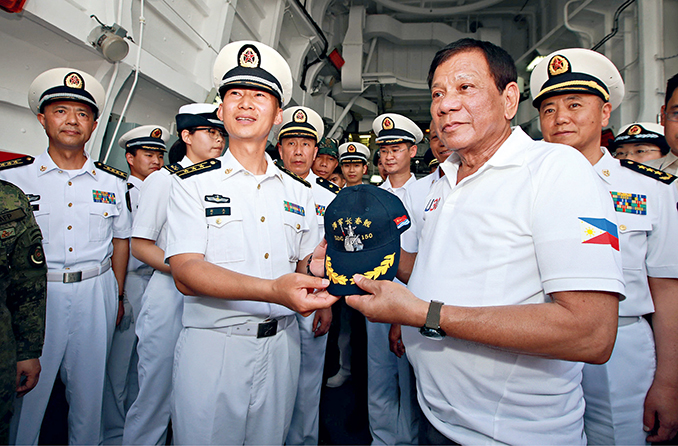 May 1, 2017: Philippine President Rodrigo Duterte (front right) receives a cap from Hu Jie (front left), captain of China’s missile destroyer Changchun, aboard the Chinese warship docked in Davao City wharf of the Philippines. The Chinese navy made a three-day friendly visit to the Philippines.