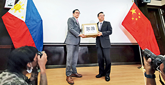 Philippine Foreign Affairs Undersecretary Brigido Dodo Dulay (left) hands anti-virus supplies to Chinese Ambassador Huang Xilian (right) on February 8. “Stay strong, Wuhan. Stay strong, China,” they chanted.