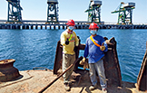 Jeff Aricila (right) poses in front of the nearly completed coal-offloading wharf.