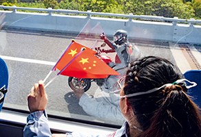 A Wuhan resident gives a thumbs up to a medical team leaving on a bus on April 6. The team, dispatched by Peking Union Medical College Hospital to help Wuhan, was returning home after the city’s situation improved. (CHEN JIAN)