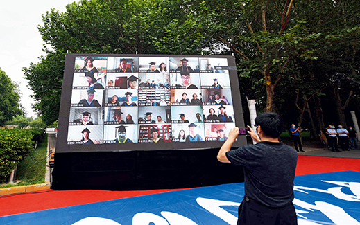 Graduates of Beihang University attend a livestreamed commencement ceremony from home on June 29, 2020. Live videos are displayed on a big screen at the ceremony.