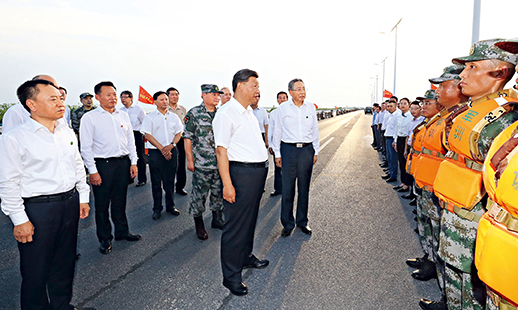 Chinese President Xi Jinping expresses gratitude to those fighting the floods on the front lines including personnel from the PLA and the People’s Armed Police Force, at a dam in Feidong County, Anhui Province, on August 19. (JU PENG/XINHUA)