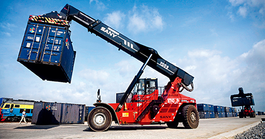 A worker at Qinzhou Railway Container Terminal uses a truck crane to lift a container on June 30, 2019. (ZHANG AILIN)