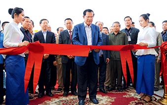 Cambodian Prime Minister Hun Sen cuts the ribbon at the completion ceremony of the Lower Se San 2 Dam. (HUANG YAOHUI)