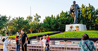 Visitors take photos with the statue of Deng Xiaoping at Lianhuashan Park．（GUO SHASHA）